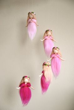 three pink fairy mobiles hanging from the ceiling, one with blonde hair and two with pink eyes