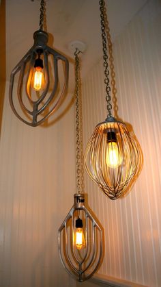 two light fixtures hanging from chains on the wall