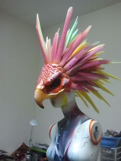 a sculpture of a bird with multicolored feathers on it's head