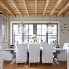 the dining room table is covered with white chairs