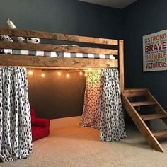 a loft bed with curtains and lights on the top is next to a stair case