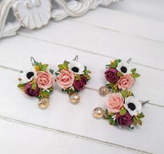 three pairs of earrings with flowers on them