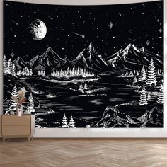 a black and white wall hanging on the side of a wooden floor next to a dresser