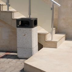 a trash can sitting on the side of some steps