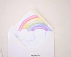 an envelope with a rainbow and clouds on it