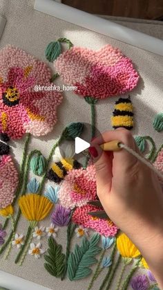 a person is working on some flowers with crochet yarn and thread in front of them