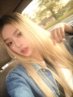 a woman with long blonde hair sitting in a car