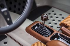 the interior of a sports car with brown leather seats and steering wheel knobs,