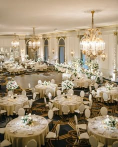 a banquet room with round tables and chandeliers in the center is set for a formal function