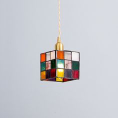 a multicolored light hanging from a gold chain