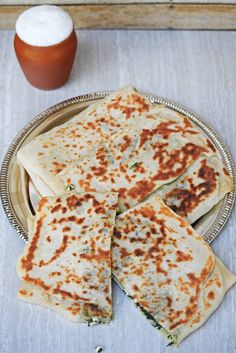 several flatbreads on a plate next to a drink