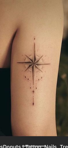 a woman's arm with a small star tattoo on it