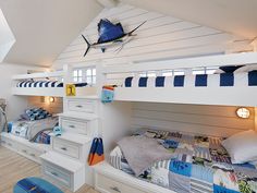 a bedroom with two bunk beds and a blue surfboard on the wall next to it