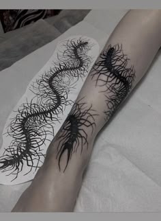 a woman's arm with black ink on it and an intricate design in the middle