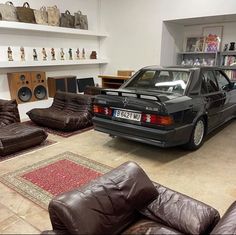 a car is parked in a room with couches and bookshelves