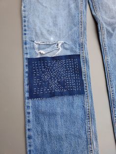 an old pair of jeans with holes in the back pocket and stitching on the side