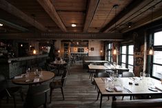 an empty restaurant with wooden tables and chairs