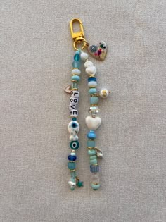 a beaded keychain with beads and charms hanging from it's side