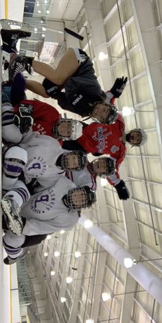 a group of young men standing next to each other on top of a hockey rink