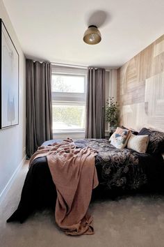 a bedroom with a large bed and wooden headboard on the wall next to a window