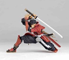 the action figure is posed with two swords