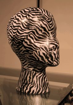 a black and white photo of a zebra head on top of a glass table in front of a mirror