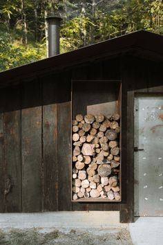 a pile of logs sitting in front of a building