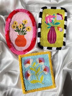 three embroidered coasters with flowers on them