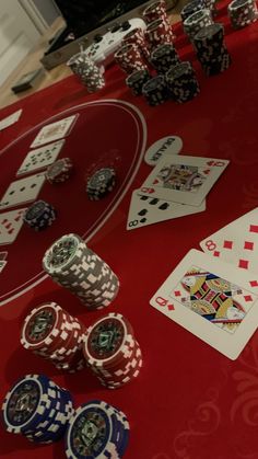 poker chips and playing cards on a red table