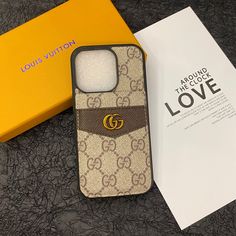 a gucci phone case sitting on top of a table next to a yellow box