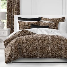 a leopard print comforter set on a white bed