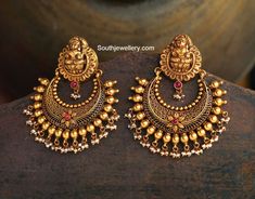 22 carat gold antique toned latest model chandbalis with Goddess Lakshmi tops from Navrathan Jewellers, Bangalore. The earrings have pearl clusters hanging at the bottom.   Related PostsAntique Lakshmi ChandbalisAntique Jhumkis Necklace with Nakshi pendantNavarathan Jewellers Latest Jewellery CollectionDivine Nakshi Temple Jewellery SetMango Haram with Ganesh MotifsAntique Gold Mesh Necklace Latest Jewellery Designs, Chandbali Earrings, Antique Jewelry Indian, Bridal Gold Jewellery Designs, Gold Jewellery Design Necklaces, Indian Wedding Jewelry, Jewelry Design Earrings