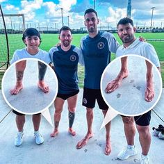 three men standing next to each other in front of a soccer field