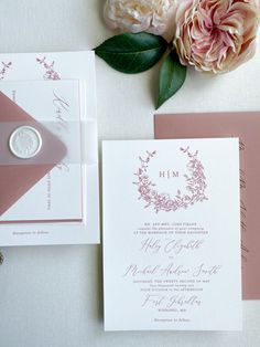 the wedding stationery is laid out on top of the table with pink and white flowers