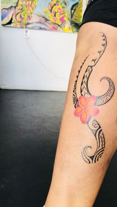 a woman's leg with a flower tattoo on her left thigh and an orange flower in the middle