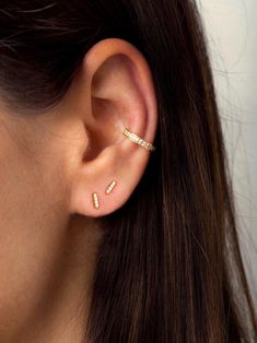 a close up of a person wearing a pair of ear piercings with diamonds on them