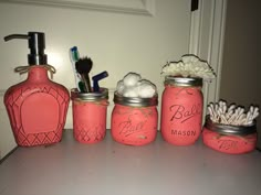 pink mason jars with personal items on top of the counter in front of a door