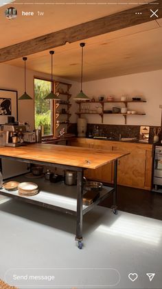 a kitchen with an island in the middle and lots of shelves on the wall above it