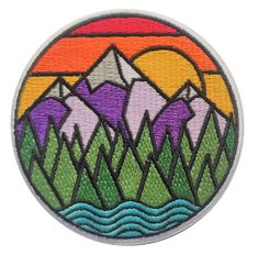 a patch with mountains and water in the middle, on a white background that says mountain sunset