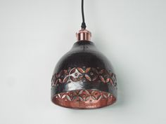 a black and copper light hanging from a wall