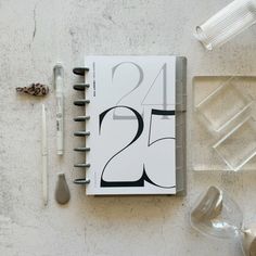 an open notebook sitting on top of a table next to some glasses and other items