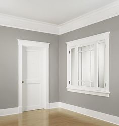 an empty room is shown with the door and window frame painted in light gray color