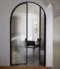 an arched glass door leading to a dining room