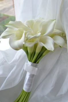 a bouquet of white flowers sitting on top of a bed