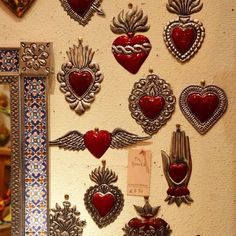 there are many red heart shaped decorations on the wall next to a mirror and other decorative items