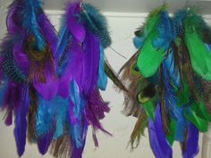 two purple and green feathers hanging from hooks