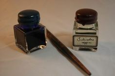 a pen and ink bottle sitting next to each other on a white tablecloth covered surface