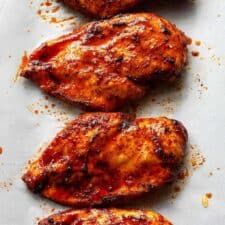 four pieces of chicken sitting on top of a white tray