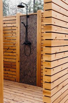 an outdoor shower with wooden walls and flooring