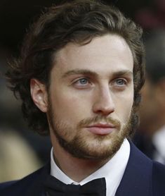 a close up of a person wearing a tuxedo and looking at the camera